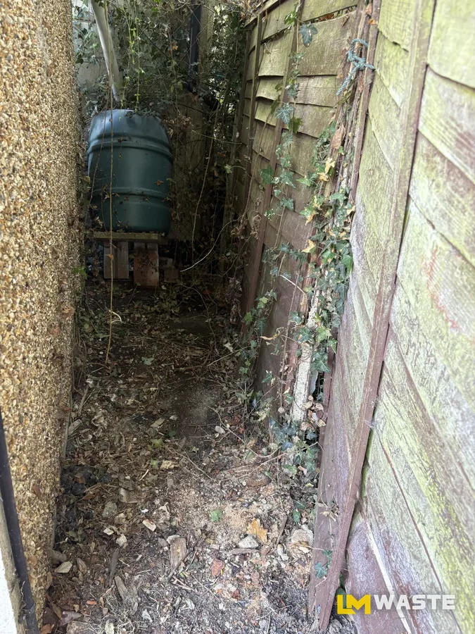 After: Side passage: old shelving, timber, pots and the ivy pulled out, water butt left where it was